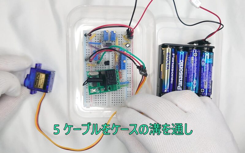 5 Pass the cable through the groove in the case. 5 ケーブルをケースの溝を通し