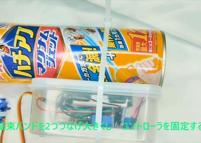 Connect two cable ties together to make a larger one and secure the controller in place. 結束バンドを2つつなげ大きくしコントローラを固定する作業